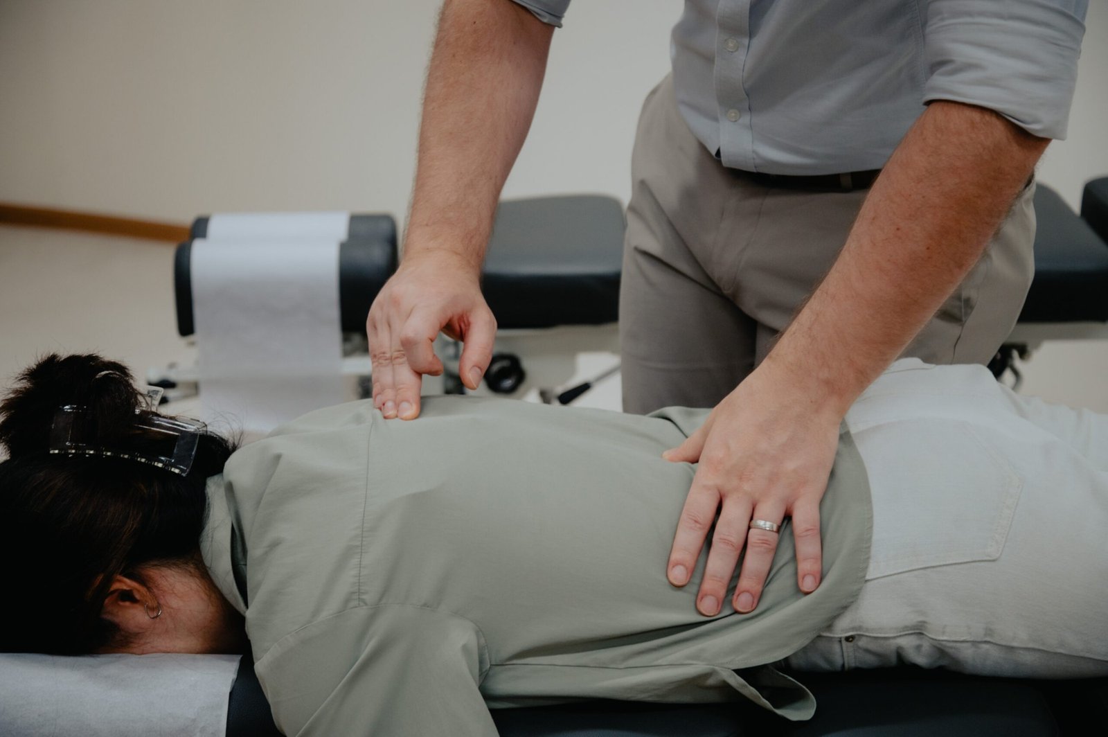 Chiropractor adjusting a patient's upper back on a treatment table