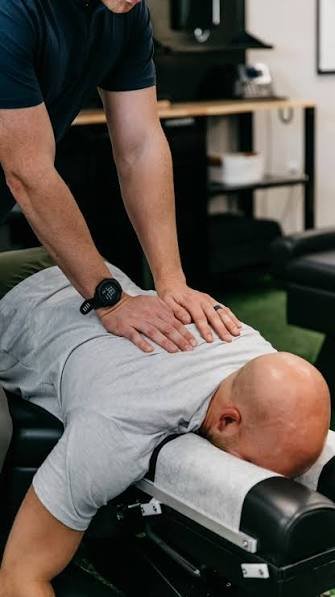 Chiropractor treating a patient's back on an adjusting table