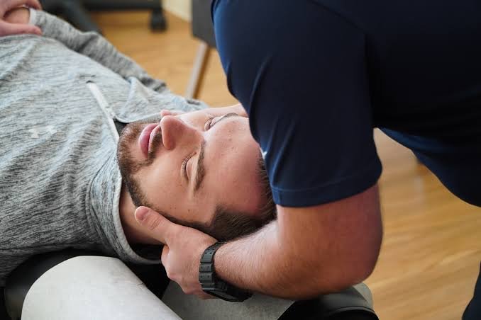 Chiropractor supporting a patient's head during a neck adjustment