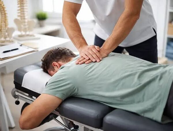 Chiropractor applying a spinal adjustment to a patient lying face down